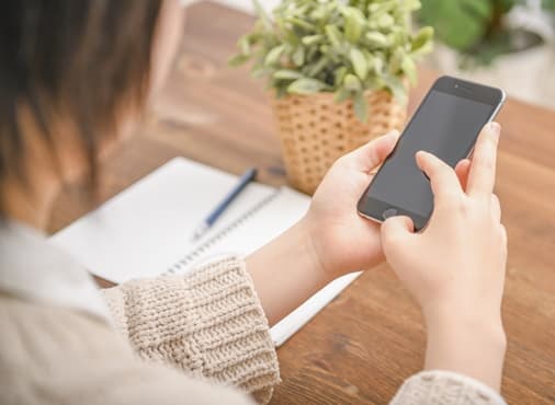 スマートフォンで問い合わせをする女性